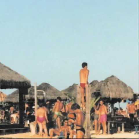 Foto antiga da Praia de Pitinga com barracas de palha e banhistas